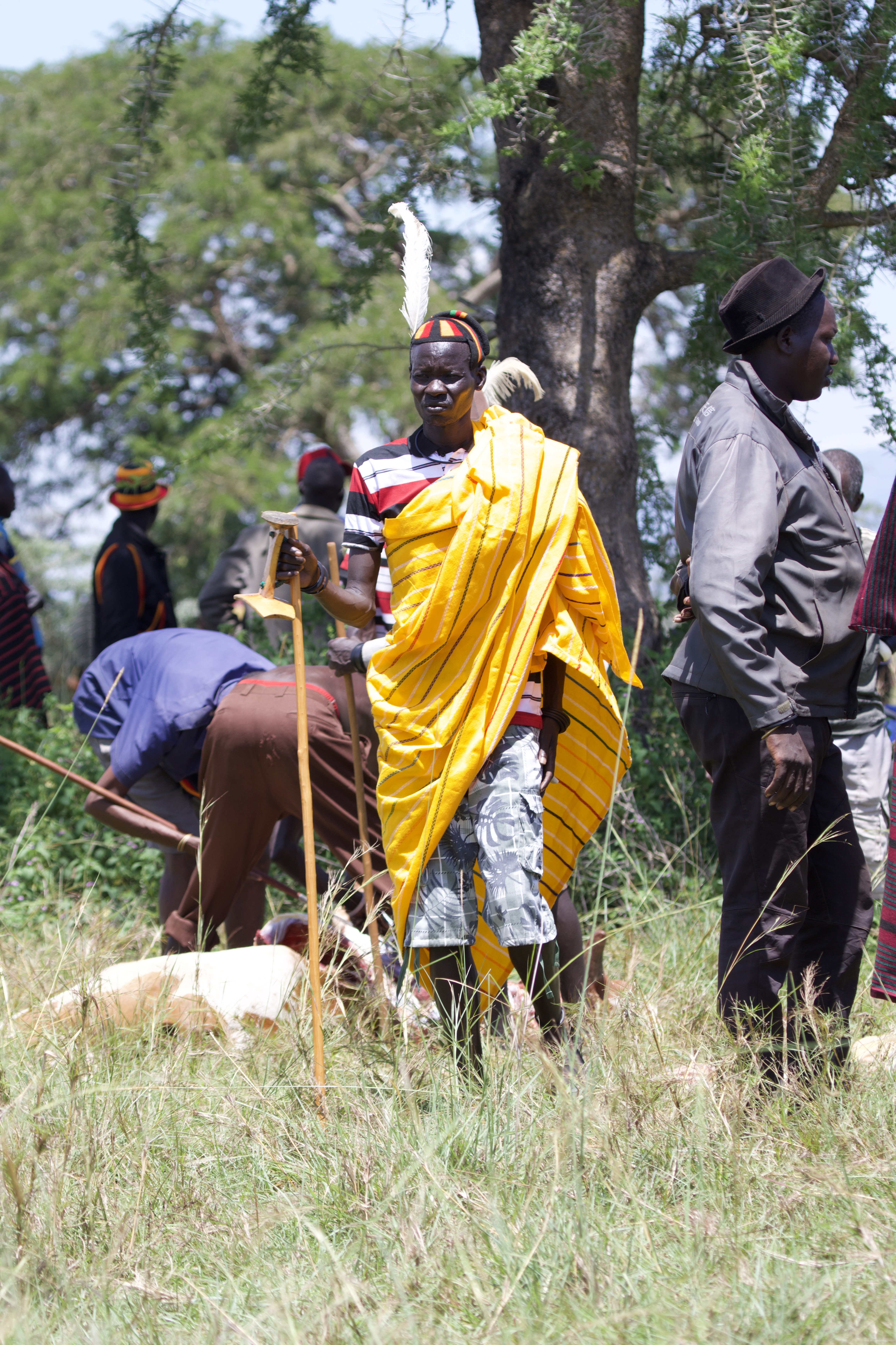A Karamojong elder in a yellow robe with ceremonial staff