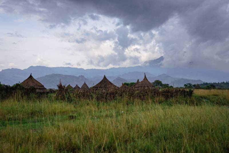 A manyatta of thatched homesteads below the mountains