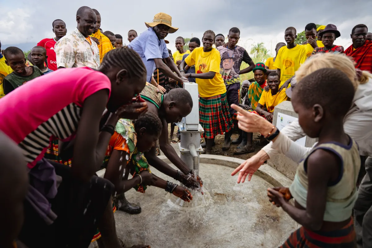 The community gathered around a new borehole as water flows