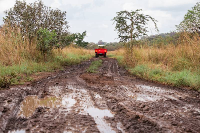 A truck tipped over on a rough earth road