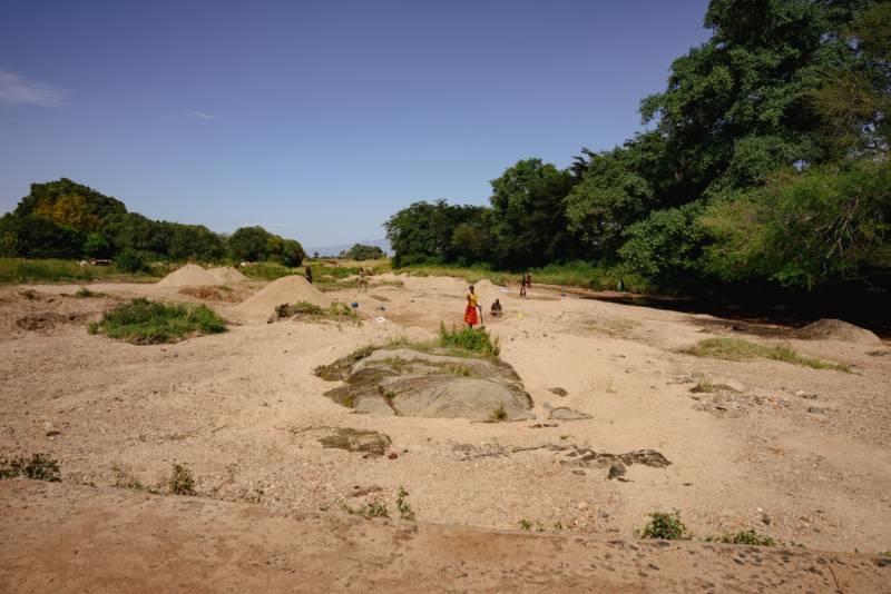People digging for water in a dry sand riverbed